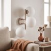 Scandinavische wandlamp Gastor met drie witte glazen bollen en zandkleurig armatuur